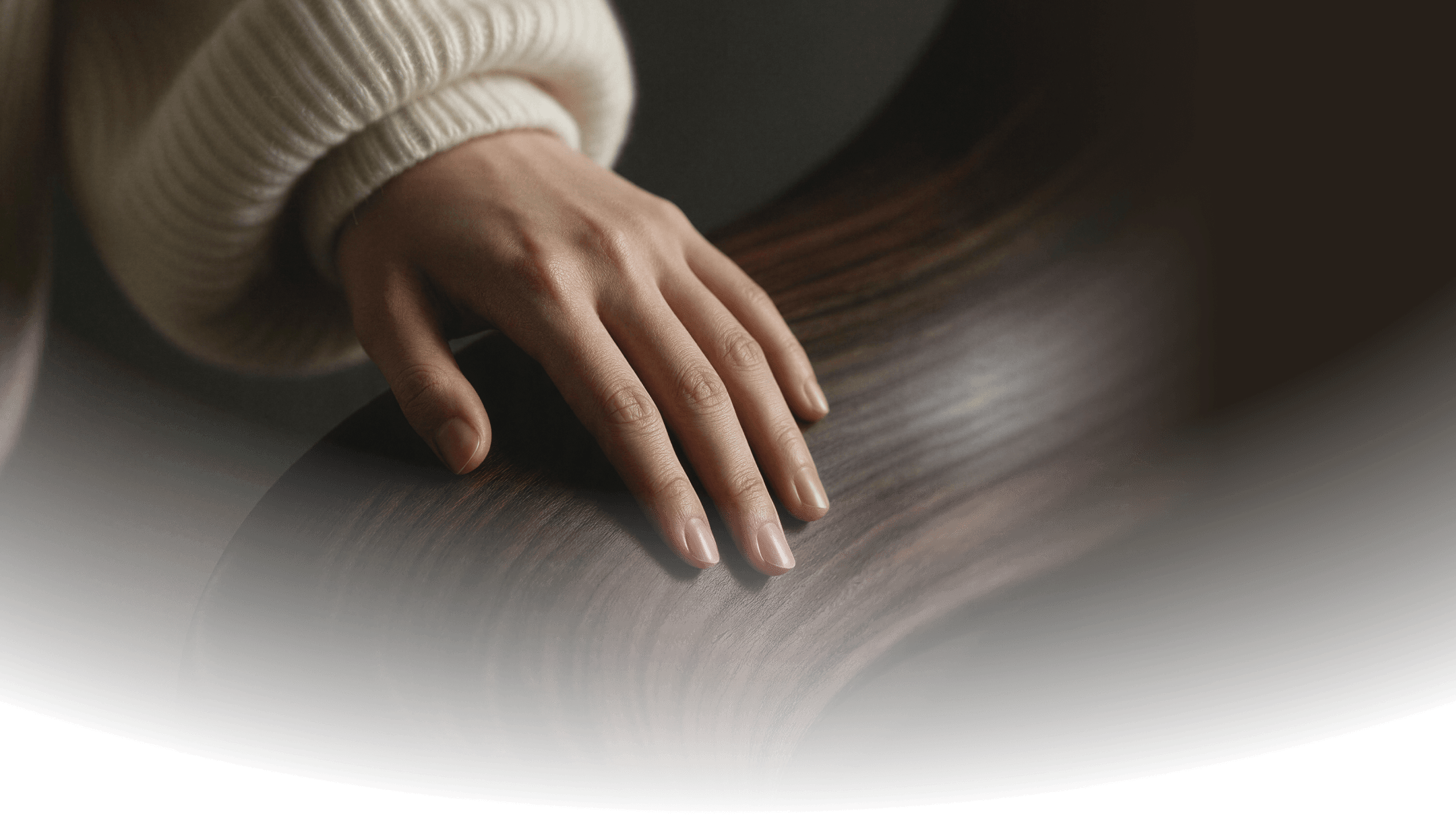 A hand resting on a curved timber surface